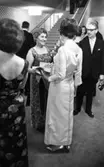 Teatergalan III den 1 mars 1965.

Uppklädd galapublik i foajén på Hjalmar Bergmanteatern.

Två damer i förgrunden.
