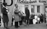 Knytkalaset 5 juli 1965.

Harald Aronsson står på scenen med en korg i händerna, flankerad av de båda värdinnorna varav den ena håller i en prispropeller. Publik i bakgrunden.