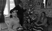 Hemma hos Karasko, 24 december 1965

Familjen Karasko bestående av mor, far och två döttrar firar jul. De är en romsk familj. Modern är klädd i traditionell romsk dräkt. De befinner sig i sitt vardagsrum. Far i huset står upp och håller sin vänstra hand på den dekorerade julgranen. Modern sitter i soffan med en nätförpackning med frukt i knät. På golvet sitter den ena dottern med en nötknäckare i handen. Den andra dottern sitter närmast kameran med en skål fylld med nötter och andra godsaker.