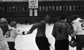 Hot rod, Kungälv - Örebro, 7 januari 1966

Fem bandyspelare står med ryggarna mot kameran i förgrunden. En klocka med poängresultat sitter på ett långt hus i bakgrunden. Åskådare står vid huset. Alla spelare har reklamtext på sina ryggar som t.ex. 