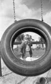 Lekplatserna tråkiga 7 juli 1965

En liten flicka med docka och korg på lekplats. En gunga i förgrunden.