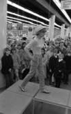 Baddräkter 12 maj 1966

En fotomodell i vit blus, färgglada byxor med bubbelmönster på, vit hatt samt sandaler går på catwalken. Publik står nedanför och tittar på.
















































































































or. Han går nedför en kort trappa utomhus.