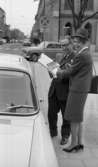Värdinnor på enkät 13 maj 1966

En värdinna klädd i dräkt, hatt och högklackade skor. Hon har en stor väska hängande på höger axel. Hon håller i ett block med ett papper med trafikmärken på med vänster hand. I höger hand håller hon en penna. En man iklädd kavaj, slips skjorta och glasögon samt skor håller också i blocket. De står tillsammans vid en parkerad vit bil. I bakgrunden kör en bil som är i färd med att göra en vänstersväng.





















































































































or. Han går nedför en kort trappa utomhus.