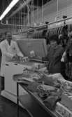 Orubricerat 18 februari 1966

En man och en kvinna står vid en frysbox i en charkuterifabrik. Mannen håller i tre paket med påskriften 
