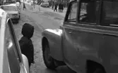 Barn i trafiken, 25 januari 1966

Barn tittar ut bakom bil för att kunna passera trafikerad gata