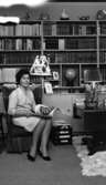Hemma hos Ignell 8 januari 1966

Medelålders kvinna poserar sittandes i vardagsrum framför bokhylla