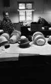 Hattfabrik läggs ned 1 mars 1966

Två arbetare i en hattfabrik. Hattar ligger på bordet i förgrunden.