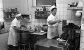 Fabriksmat, 9 mars 1966

Två kokerskor klädda i vitt arbetar i ett kök.