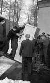 Nationalmuseum 1 31 maj 1966

Flera män hjälps åt att lasta av en stor trälåda från en bil som är parkerad utanför Länsmuseet. En man i kostym med ryggen åt kameran står beredd med en säckkärra att köra lådan på.