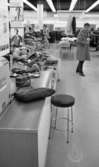 Väsktjuvar, Malmströms, Studenten 2, Väsktjuvar 20 april 1966

En handväska ligger i förgrunden på en disk. Nedanför disken står en pall. I bakgrunden syns en man klädd i rock och byxor som betraktar väskan. Hyllor med varor syns runtomkring.