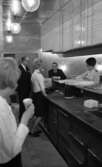 Teatergrillen den 11 mars 1965.

I restaurangen. Serveringspersonal och två män i kostym.
