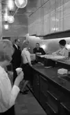 Teatergrillen den 11 mars 1965.

I restaurangen. Serveringspersonal och två män i kostym.
