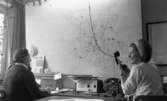 Taxi, 14 februari 1966

Två kvinnor sitter i en ledningscentral på Taxi. En karta sitter på väggen.