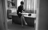 Telefonreportage, 31 januari 1966

En kvinna sitter på kanten på ett bord och talar i telefon. Telefonen är svart. Kvinnan är klädd i en kort klänning och har sandaler på fötterna. I bakgrunden finns ett fönster med gardiner runt omkring.