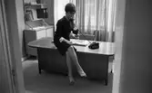Telefonreportage, 31 januari 1966

En kvinna sitter på kanten på ett bord och talar i telefon. Telefonen är svart. Kvinnan är klädd i en kort klänning och har sandaler på fötterna. I bakgrunden finns ett fönster med gardiner runt omkring.