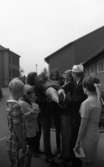 Skolavslutning 11 juni 1966

Ett antal tonårsflickor- pojkar hissar en flicka i samma ålder på en skolgård under en skolavslutning.