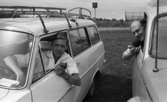 Beg. bilar, Ferieskola, Bodenkille slog rekord 14 juli 1966

Två män sitter i var sin bil och håller i var sin högtalarmikrofon. Mikrofonerna hör till radioapparater som står inne i bilarna.