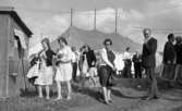 Helgelseförbundet, Japan på Svampen 24 juni 1966

I förgrunden stär ett antal kvinnor i klänningar och några herrar i kostymer. Bakom dem syns två stora vita tält som tillhör Helgelseförbundet.