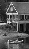 Loka brunn 2 22 juli 1966

Två herrar varav den ena har bar överkropp och den andra är klädd i vit skjorta, mörk slips och mörka byxor är ute i en eka i vattnet nära Loka brunn. Mannen i skjorta ror. I bakgrunden syns ett hus med en bil parkerad nära intill.