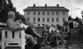 Svartå Herrgård 1 28 juli 1966

Fem vuxna varav två herrar, tre damer samt även tre barn befinner sig i trädgården på Svartå Herrgård i Örebro. En tax finns också med på bilden. En av herrarna har ljus kostym på sig och den andre herrn röker pipa. Personerna sitter på två bänkar.