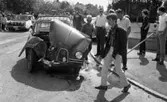 Krock Baronbacken, 7 augusti 1967

I förgrunden syns en ung man klädd i svart skinnjacka, randig skjorta, vita byxor och ljua knytskor går över gatan. Precis bakom honom står en bil som varit med i en krock och fått en skadad motorhuv. En polisbil syns i bakgrunden. Massor med folk står runtomkring på trottoarerna och tittar på. En ung man i overall står längre bort med ryggen mot kameran.