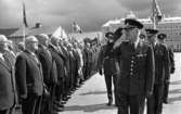 Kungen I3 28 augusti 1967

Kung Gustav VI Adolf besöker Örebro Livregementes Grenadjärer i Grenadjärsstaden. Han gör honnör när han passerar förbi en linje med uppställda soldater och veteraner tillsammans med en grupp miltära befäl. Andra soldater syns i bakgrunden.