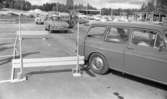 Orubricerad 21 augusti 1967

Personer sitter i olika bilar på en parkering. De är i färd med att köra iväg. Ett hus syns i bakgrunden till vänster.