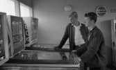 Knuttarna har bil 24 juli 1967

Två tonårspojkar spelar flipperspel i en fritidslokal. Den ene är klädd i mörk långärmad tröja, vit skjorta och mörka byxor. Den andre är klädd i mörk jacka och mörka byxor. Det står flera flipperspel i lokalen.
