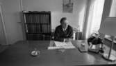 Fångvårdsdirektör Kumla 13 juli 1967

En fångvårdsdirektör i Kumla sitter inne på sitt kontor vid ett skrivbord. Han är klädd i mörk kostym, vit skjorta och mörk slips. han håller en cigarett i höger hand. Två telefoner, en anropstelefon samt en askkopp står på bordet bl. a. Ett anteckningsblock, en penna och en kalender ligger också på skrivbordet framför fångvårdsdirektören.