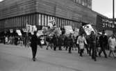 Första maj demonstration 2 maj 1967

Ett första-majtåg går förbi varuhuset Krämaren i centrala Örebro. Många av deltagarna bär på skyltar med texter på. Banderoller förekommer också. Många män bär kavajer och byxor. Vissa är klädda i rockar. Kvinnorna är klädda i kappor.