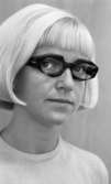 Glasögon 28 juli 1967

Närbild på en ljushårig kvinna med pagefrisyr. Hon har ett par mörka glasögon och en vit tröja på sig samt vita pärlörhängen.