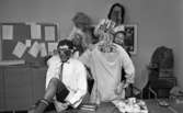 Luciafirandet 13 december 1966

Sex unga män är utklädda i komiska maskeradkläder. En av dem bär en Luciakrona med ljus i på huvudet. Han står med ryggen mot kameran och har en uppslitsad del av skjortan upptill där ett par målade ögon skymtar fram på hans bara rygg. En annan bär överdimensinerade glasögon. Alla är målade i sina ansikten.