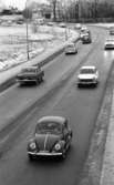 Länsläkaren, Trafiken 24 december 1966

Ett antal bilar och en bil med husvagn kör på en gata. Det ligger snö på marken. Hus syns i bakgrunden.