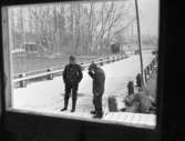 Vinöfärjan, Bandy, Hockey 6 december 1967

Två äldre herrar samtalar utomhus på en gata. Det snöar mycket. En bil kör förbi i bakgrunden.