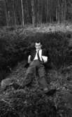 Jobbet och vi, Snickerifabrik 18 maj 1965

En man i kostym som ligger på backen vid en skogsdunge.