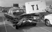 Åman krockade, 31 maj 1968

Landshövding Walter Åman har krockat med sin bil. Den syns på bilden stående med intryckt framrede på en parkering. En annan bil som har krockat står parkerad i bakgrunden. Någon håller en skylt i bildens förgrund där det står T1.