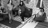 Zigenare 21 oktober 1967

Två unga zigenarflickor dansar hemma i familjens vardagsrum. De är klädda i moderna kläder. Flickan till vänster är klädd i ljusrandig, skjorta, Jeans och mörka stövlar och flickan till höger är klädd i mörk tröja, svarta byxor och vita stövlar. I bakgrunden sitter fyra vuxna kvinnor: två i varsin fåtölj samt två i en soffa. De vuxna kvinnorna är klädda i blusar och kjolar. Ett bord med blommor i en vas som står ovanpå en duk syns till vänster. För fönstret till höger i bakgrunden hänger gardiner. En radio står även på fönsterkarmen i fönstret.