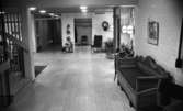 Ålderdomshotellet i Fjugesta 15 januari 1968

Interiör från entrén i ett ålderdomshem i Fjugesta. I förgrunden står en soffa. I bakgrunden står fåtöljer. En klocka samt tavlor hänger på väggen. Till vänster i förgrunden syns en trappa.