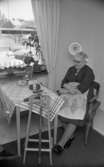 Ålderdomshotellet i Fjugesta 15 januari 1968

En äldre dam sitter inne på sitt rum på ålderdomshemmet. Hon sitter vid ett bord som har en vitrandig duk på sig. På detta ligger en socka som tillhör en stickning som hon håller på med då och då. En skål, en korg och ett garnnystan finns även på bordet. Hennes käpp hänger på en träställning.