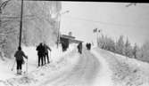 Ånnaboda 12 februari 1968

Ett antal personer varav vissa har skidor på fötterna och  stavar i händerna är på väg uppför backen nära restaurangen i Ånnaboda.