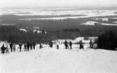 Ånnaboda 29 januari 1968

En grupp personer står i en skidbacke i Ånnaboda. De har ryggarna mot kameran. Det ligger fullt av snö på marken.