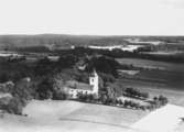 Flygfoto över Svennevad, kyrkan, bostadshus och byggnader.