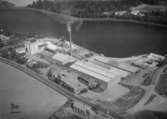 Flygfoto över Hammars Glasbruk, fabriksbyggnader.
Bilden tagen för vykort.
