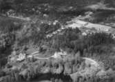 Flygfoto över Kårberg, fabriksbyggnader och bostadshus.