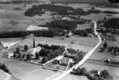 Flygfoto över Glanshammar: Glanshammars kyrka, bostadshus och byggnader.
Bilden tagen för vykort. Förlag: Alvar Liljedahl, Glanshammar.