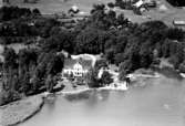 Flygfoto över Ekebergs Herrgård, bostadshus och byggnader.
Bilden tagen för vykort. Förlag: Henrik Anderssons Eftr. Lillkyrka.