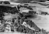 Flygfoto över Håkanbol, bostadshus och ekonomibyggnader.