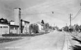 Odensbacken, gatuparti, bostadshus byggnader.
Bilden tagen för vykort.
Förlag: Odensbackens Handels AB; Odensbackens Tobaks & Pappershandel.