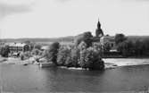 Askersunds Landskyrka, exteriör.
Tvåvånings bostadshus till vänster på bilden.
Bilden tagen för vykort.