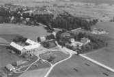 Flygfoto över Sanna gård, Fjugesta, bostadshus och ekonomibyggnader.
Bilden tagen för vykort.